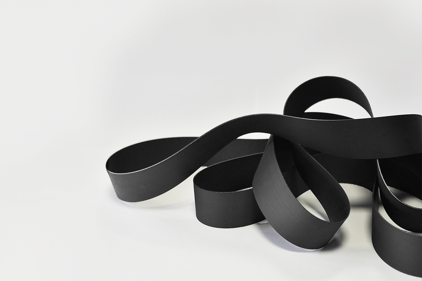 black NBR belts lying on white floor