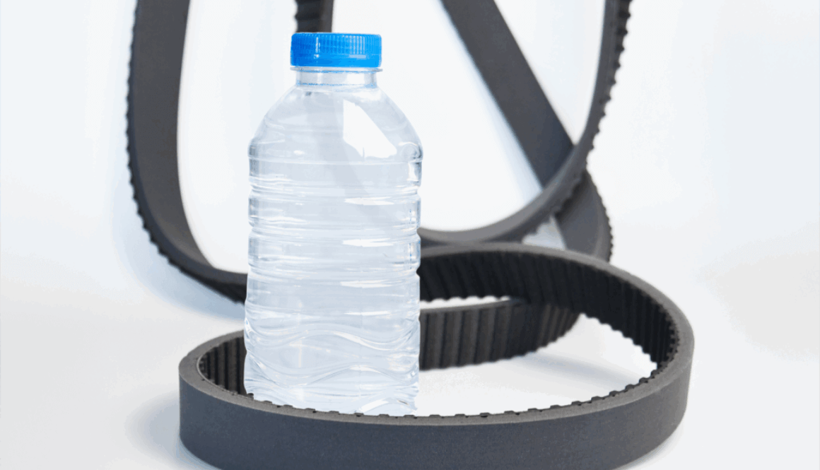 Bottle unscramblers: Belts lying on white floor around plastic bottle