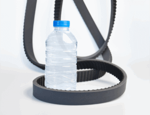 Bottle unscramblers: Belts lying on white floor around plastic bottle